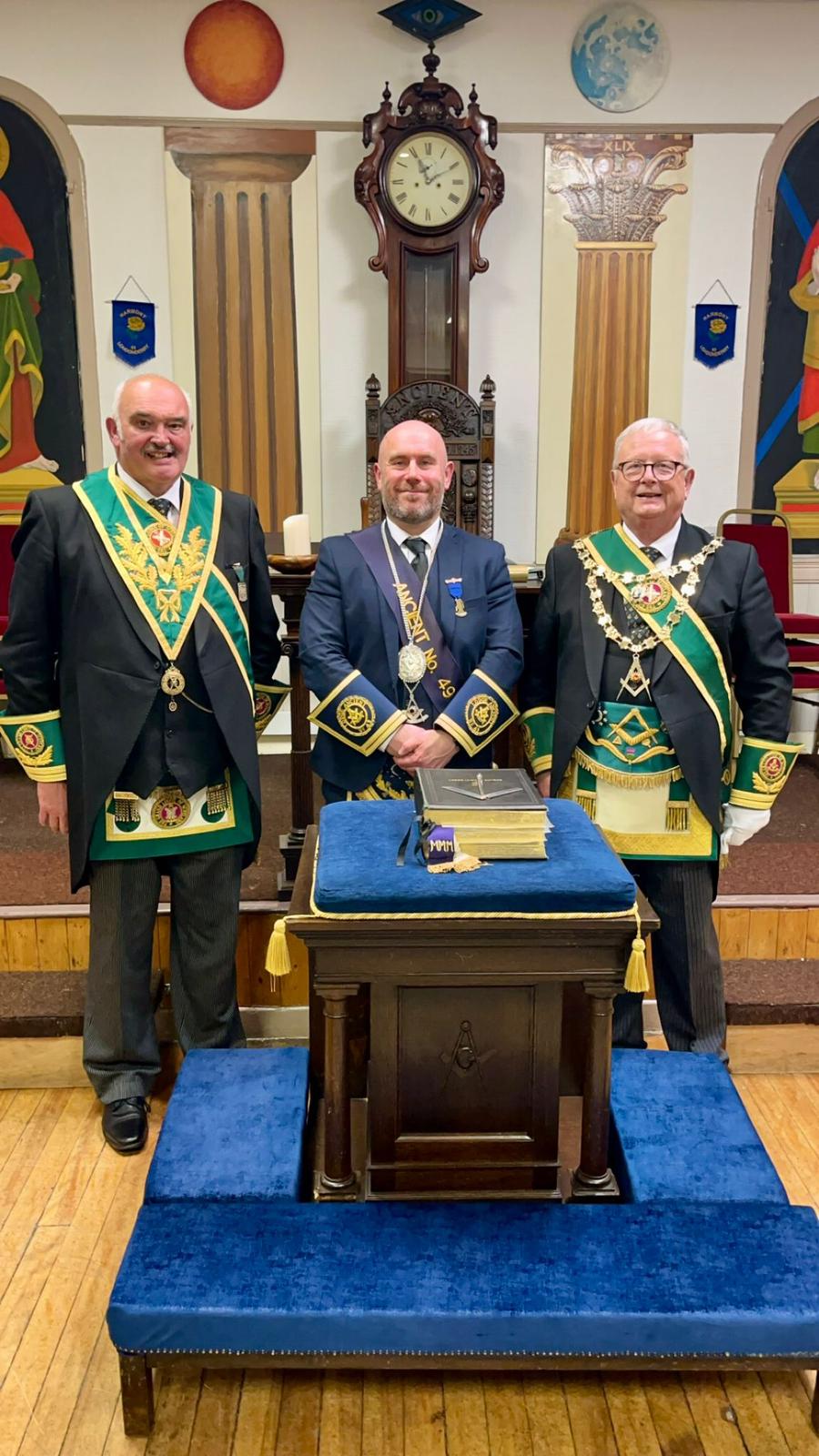 Three Freemasons standing in the Lodge room following a meeting