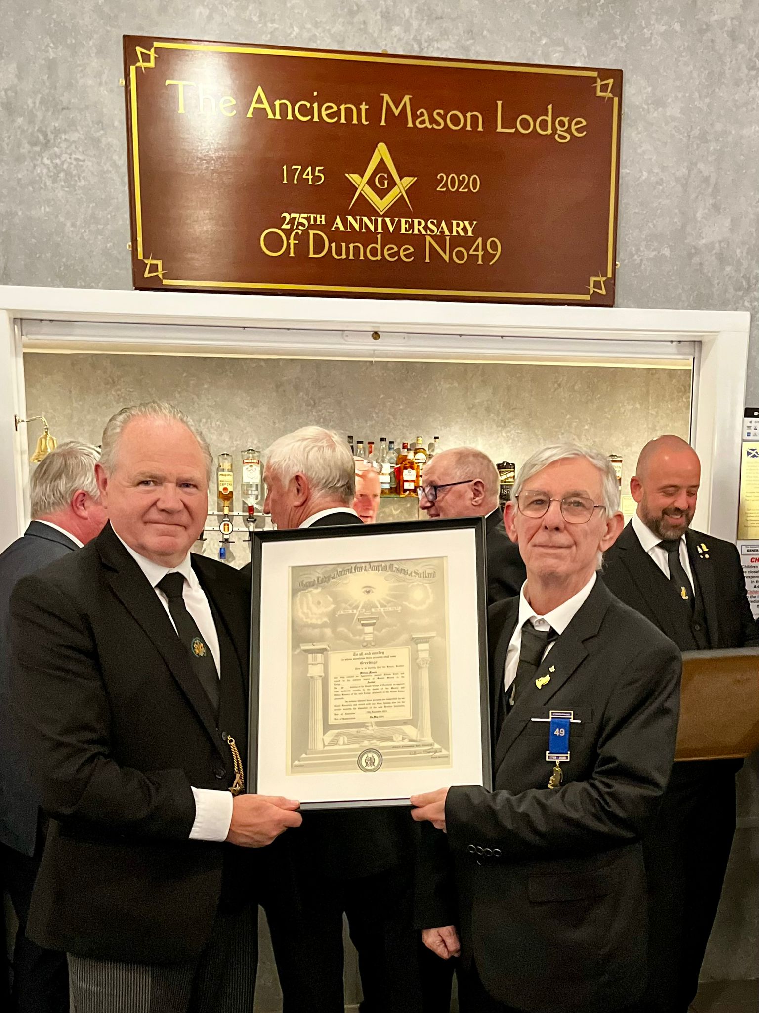 Members presenting a framed historical item at Lodge Ancient No. 49